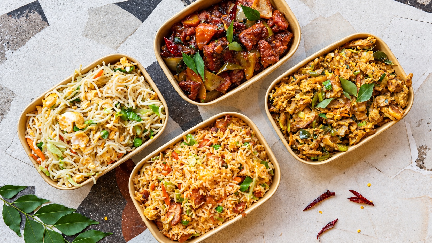 Kottu, chilli chicken, fried rice and noodles in takeaway boxes